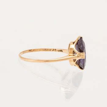 An 18K gold ring set with a synthetic colourchange purple sapphire.