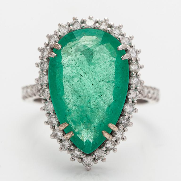 A 14K white gold ring, with a pear-cut  emerald ca. 7.72 ct and diamonds.
