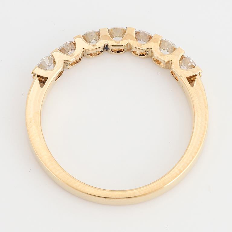 An 18K gold ring set with round brilliant cut diamonds.