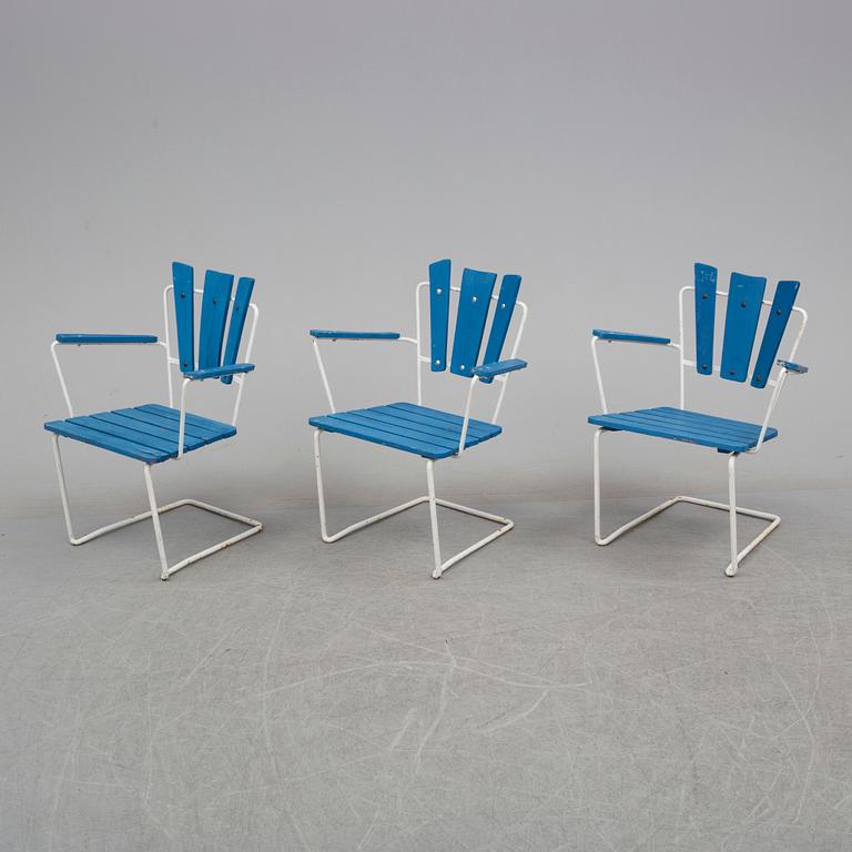 A mid 20th century garden table and three chairs.