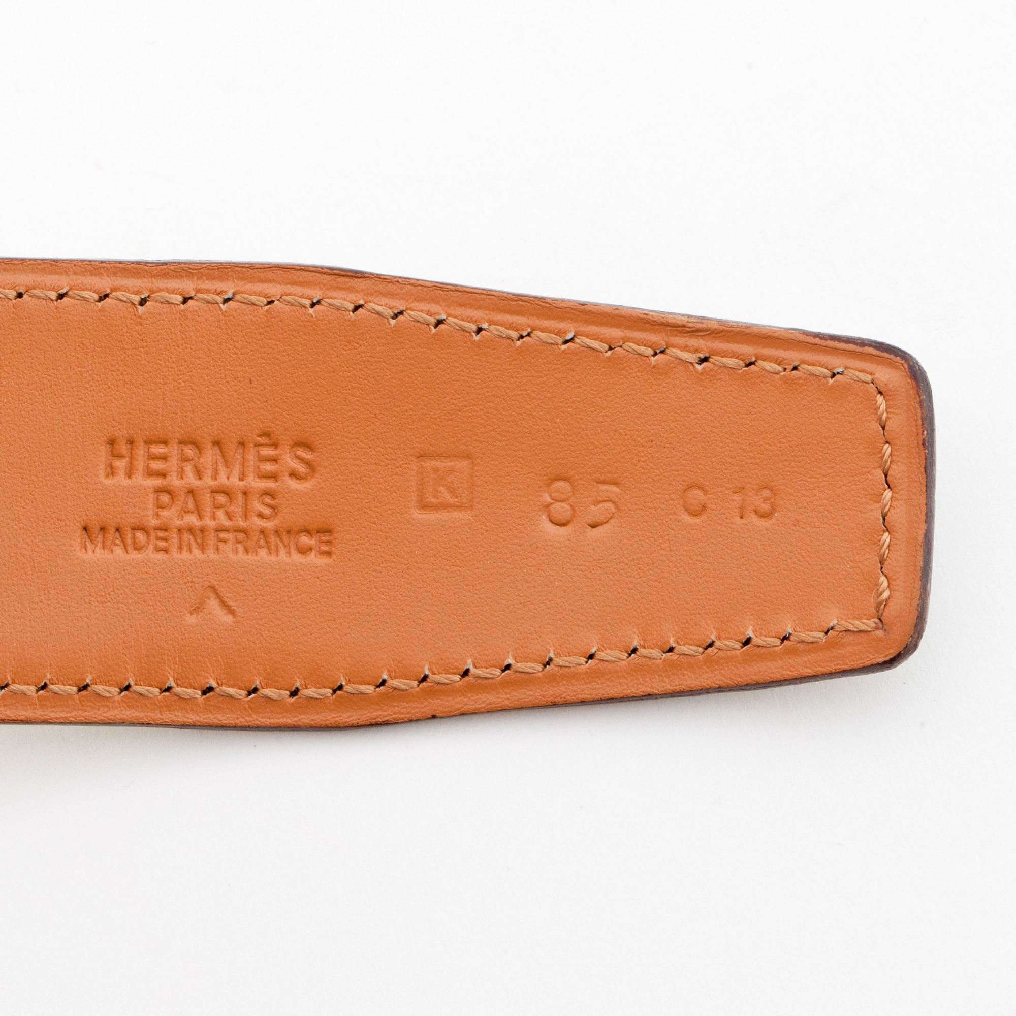HERMÈS, a green crocodile belt with silver colored H belt buckle.