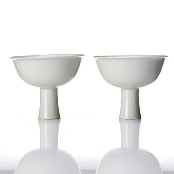 A pair of white glazed anhua stemcups, Qing dynasty, 19th Century.