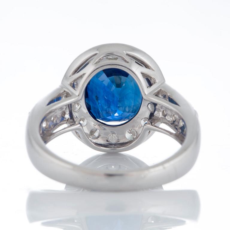 A ring set with a faceted sapphire 4.99 cts according to information given and round brillliant-cut diamonds.