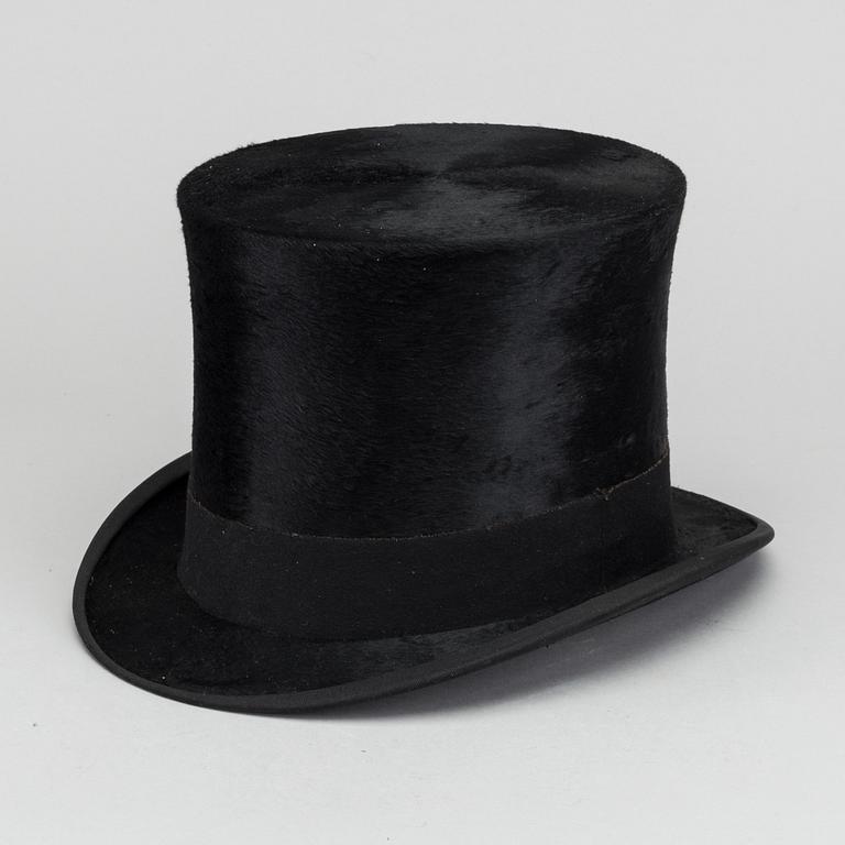 A LEATHER HAT BOX WITH A TOP HAT, 19th century latter part / turn of the century 1900.