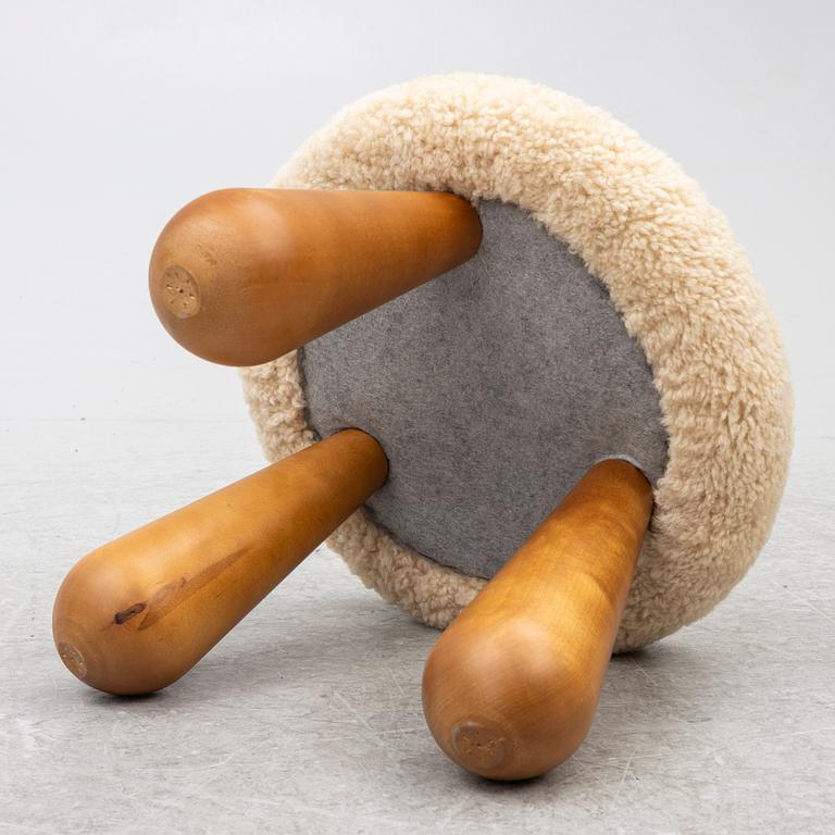 A contemporary stool with birch legs and new sheepskin upholstery.