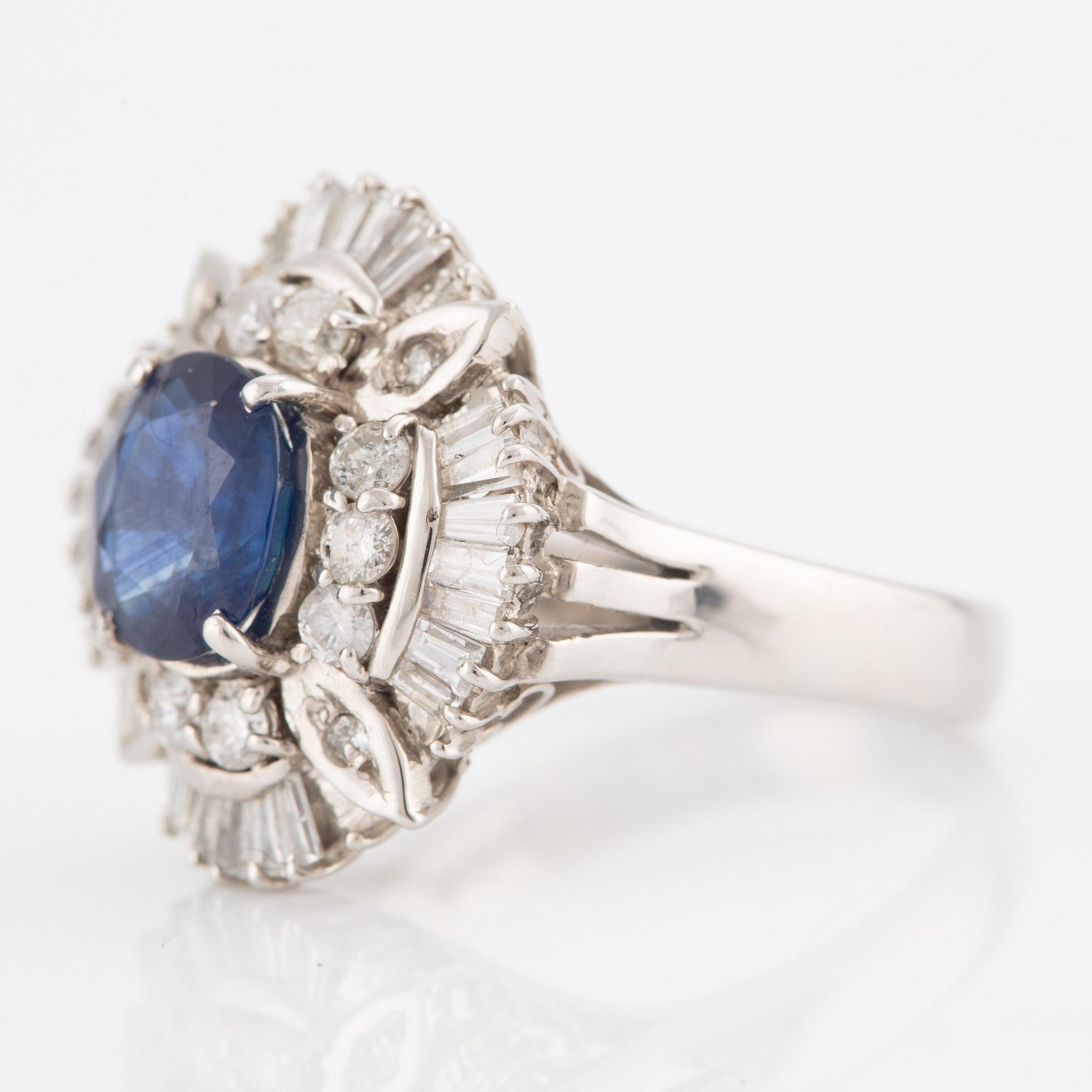 Ring in platinum set with a faceted sapphire and round brilliant- and baguette-cut diamonds.