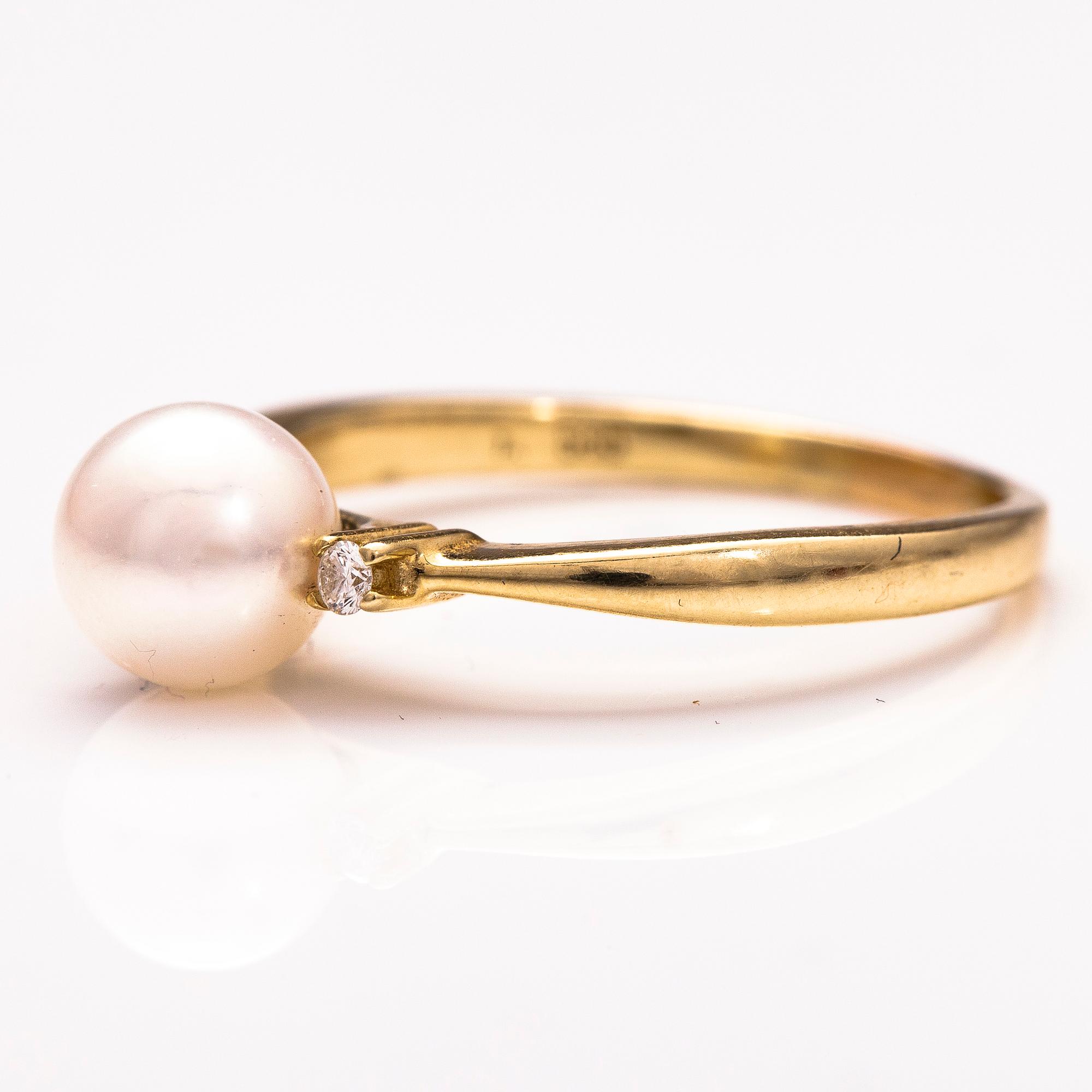 A 14K gold ring wirh diamonds ca 0.10 ct in total and a cultured pearl.