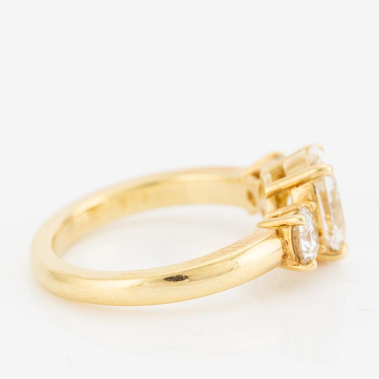 A ring in 18K gold with an oval brilliant-cut diamond and two round brilliant-cut diamonds.