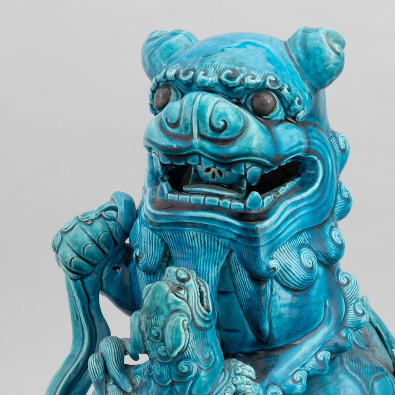 A Chinese seated buddhist lion on a plinth, 20th century.