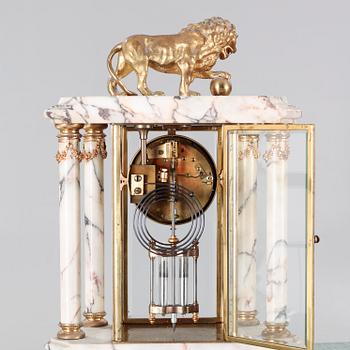 A Louis XVI style table clock and two urns, around the year 1900.