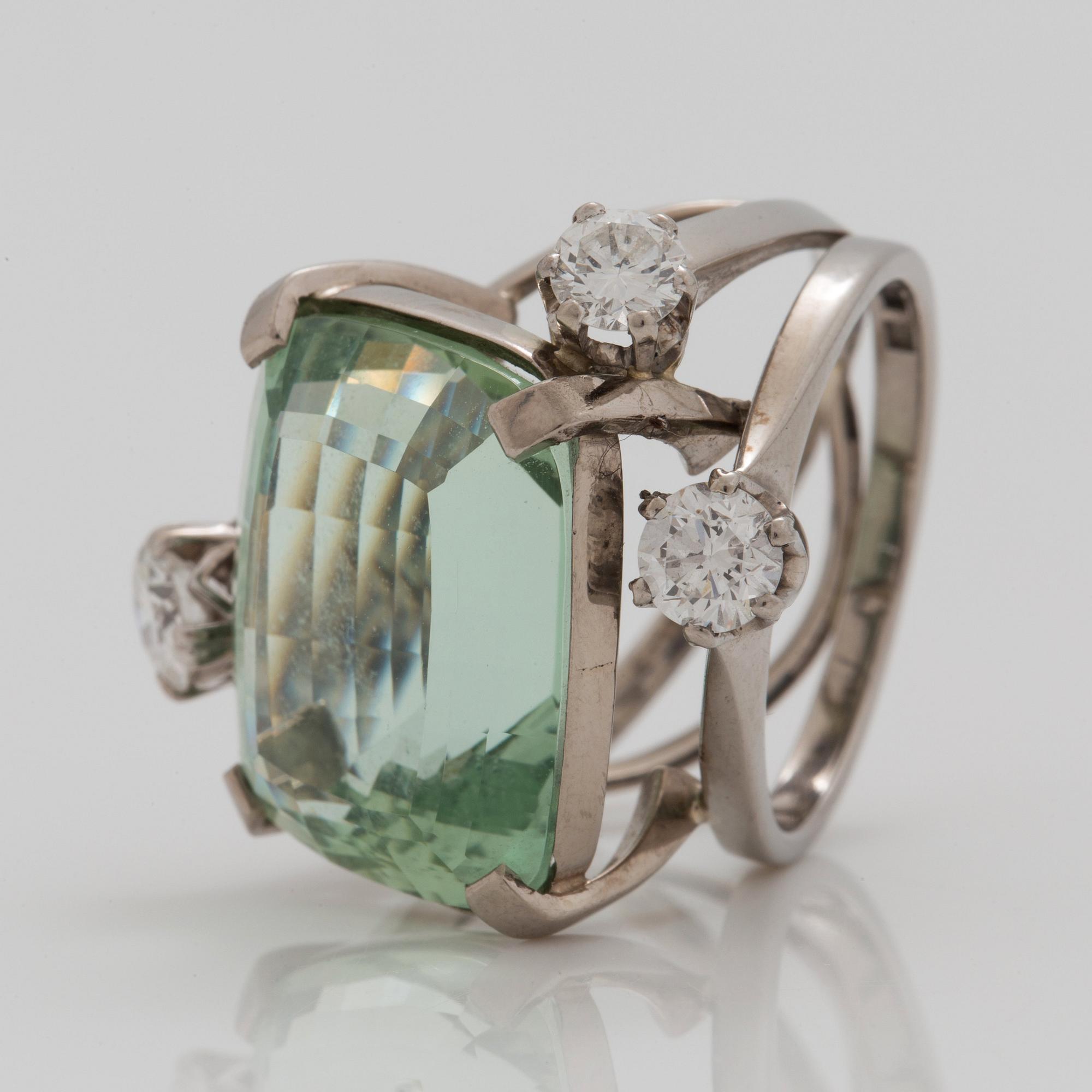 A circa 17.00 ct green beryl and brilliant cut diamond ring. Total carat weight of diamonds circa 1.29 cts.