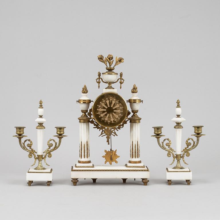 A Louis XVI style pendulum clock and a pair of candelabra, early 20th century.