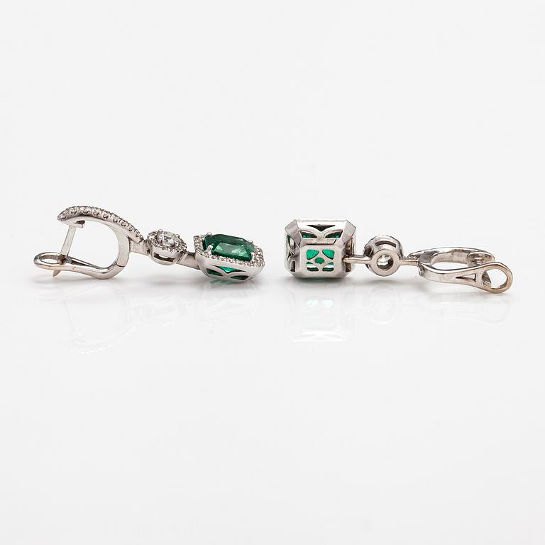 A pair of 18K white gold earrings with diamonds ca. 1.05 ct in total and emeralds ca. 4.20 ct in total. With certificate.