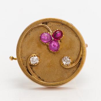 A 14k gold brooch with diamonds ca. 0.12 ct in total and rubies, of which one is synthetic.