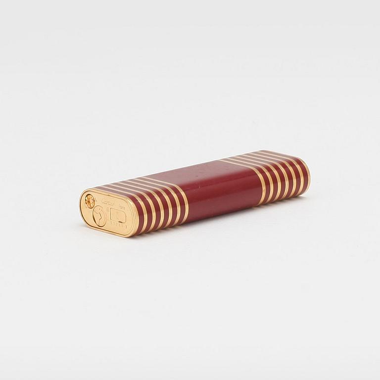 CARTIER, a red and gold lacquer lighter.