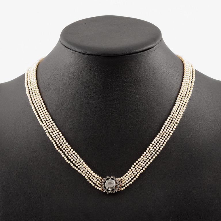 A five-strand pearl necklace with a rose-cut diamond silver and 14K gold clasp with small rose-cut diamonds.
