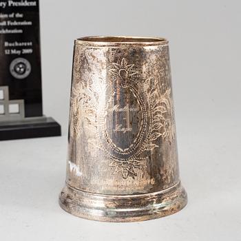 A WHITE METAL SCULPTURE, A CUP AND A BOWL.