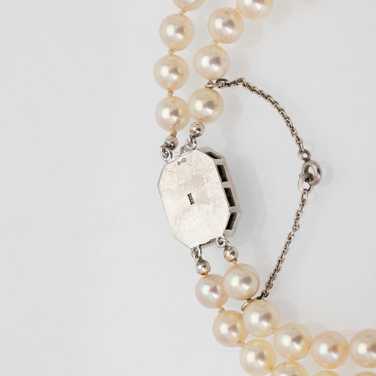 Two-row cultured pearl necklace with a silver and glass clasp.