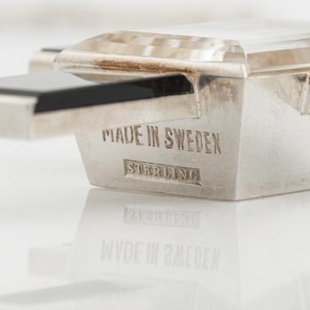 Wiwen Nilsson, hängsmycke i form av ett kors i sterlingsilver med fasettslipad bergkristall och onyx, Lund 1939.
