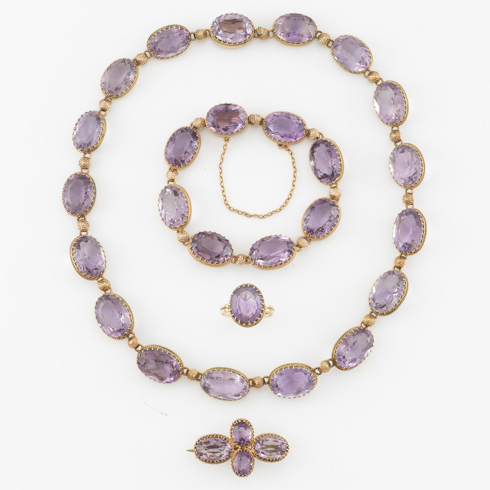 A set with a necklace, a bracelet, a brooch, and a ring.