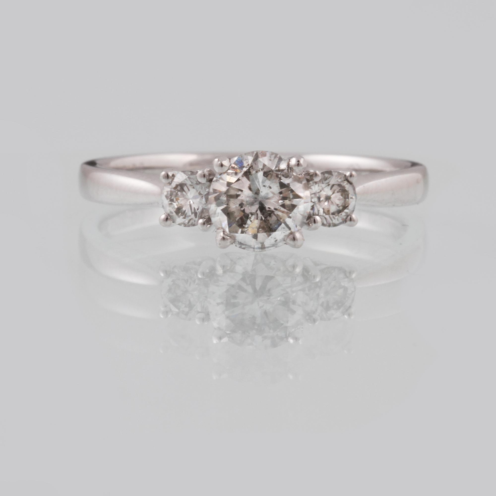 RING, 18K vitguld med en briljantslipad diamanter ca 0.70 samt 2 briljantsliapde diamanter ca 0.23 ct. Vikt 2,5 gram.