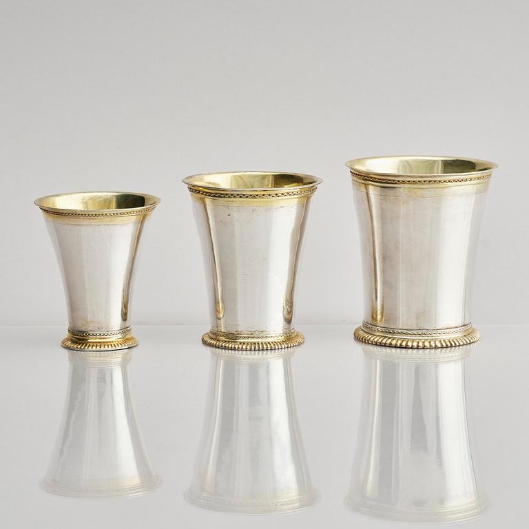 Three Swedish 18th century parcel-gilt silver beakers and a case of birch, different maker's.