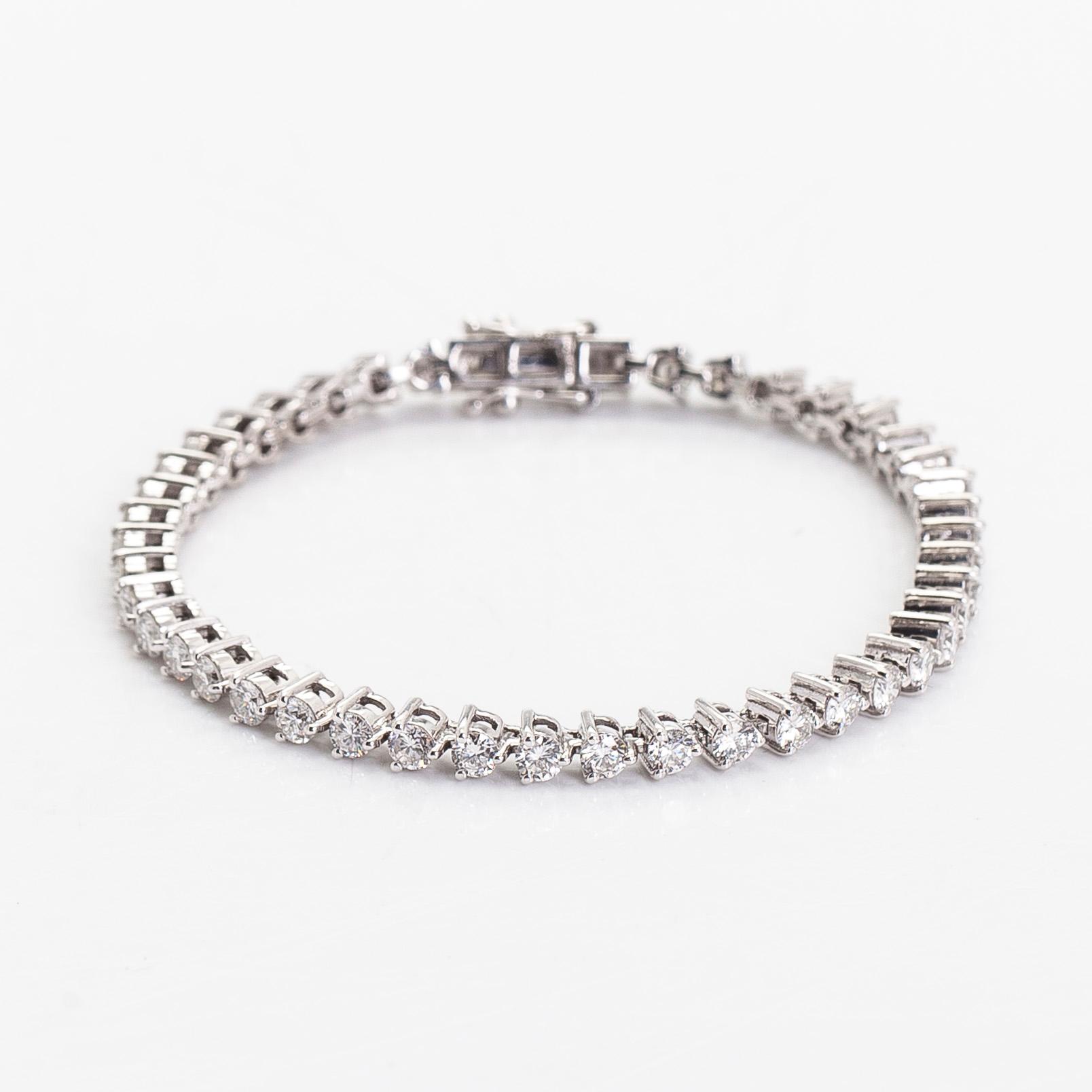 An 18K white gold tennis bracelet, with brilliant-cut diamonds.