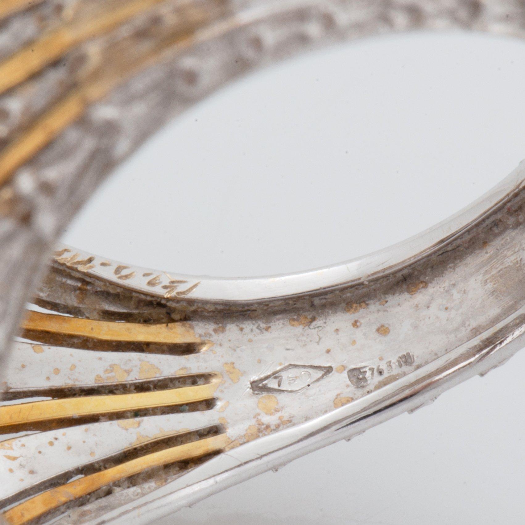 An 18K gold ring set with a cultured pearl and round brilliant-cut diamonds.
