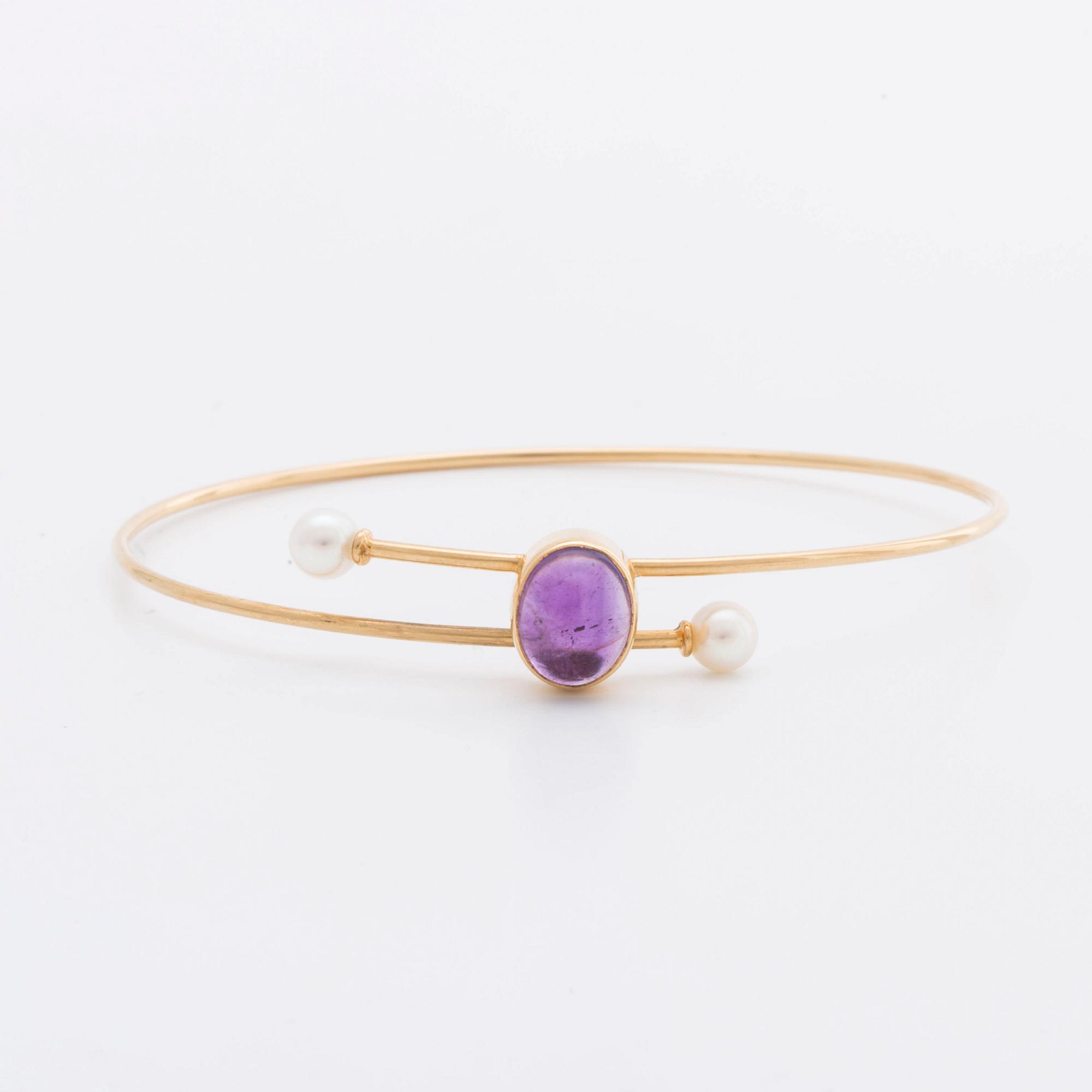 ARMRING 18K guld med 1 cabochon-slipad ametist ca 11 x 7 mm samt 2 odlade pärlor ca 5 mm, 1962.