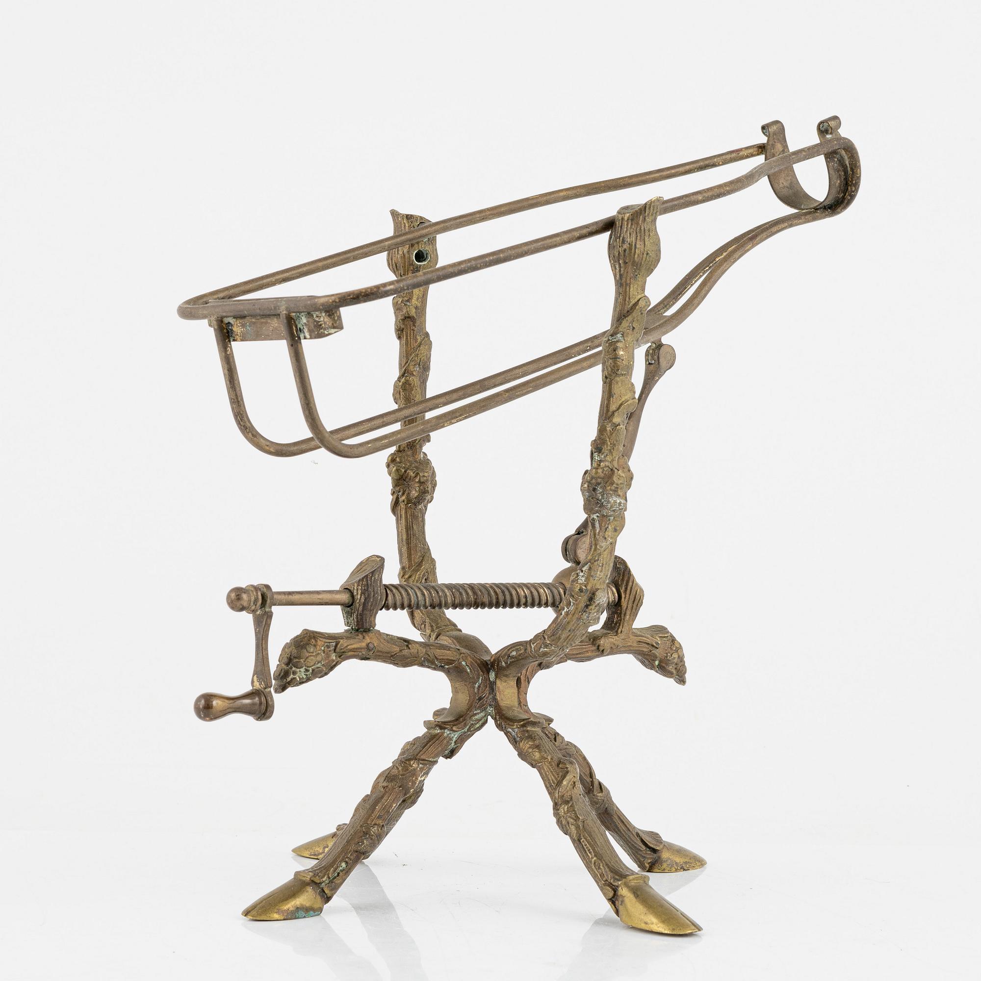 A brass bottle holder, circa 1900.