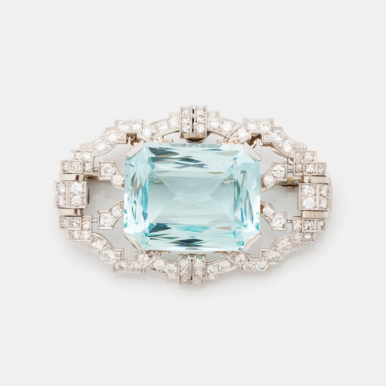 A platinum brooch set with an aquamarine and round brilliant- and eight-cut diamonds.