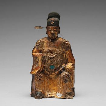 657. A lacquered and gilt ceramic sculpture of a deity, Ming dynasty (1368-1644).