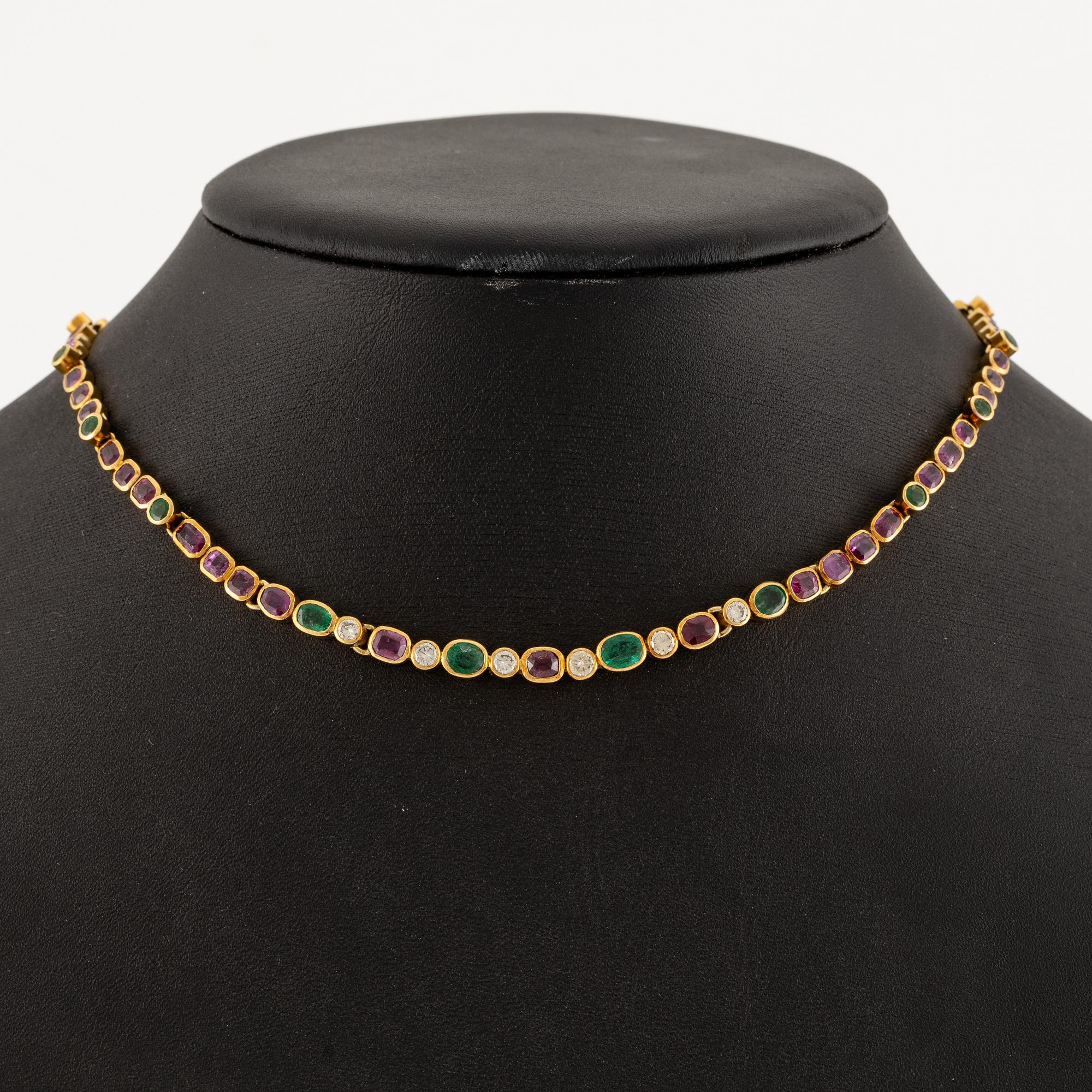 Andrew Grima, collier 18K guld med runda briljantslipade diamanter samt rubiner och smaragder.