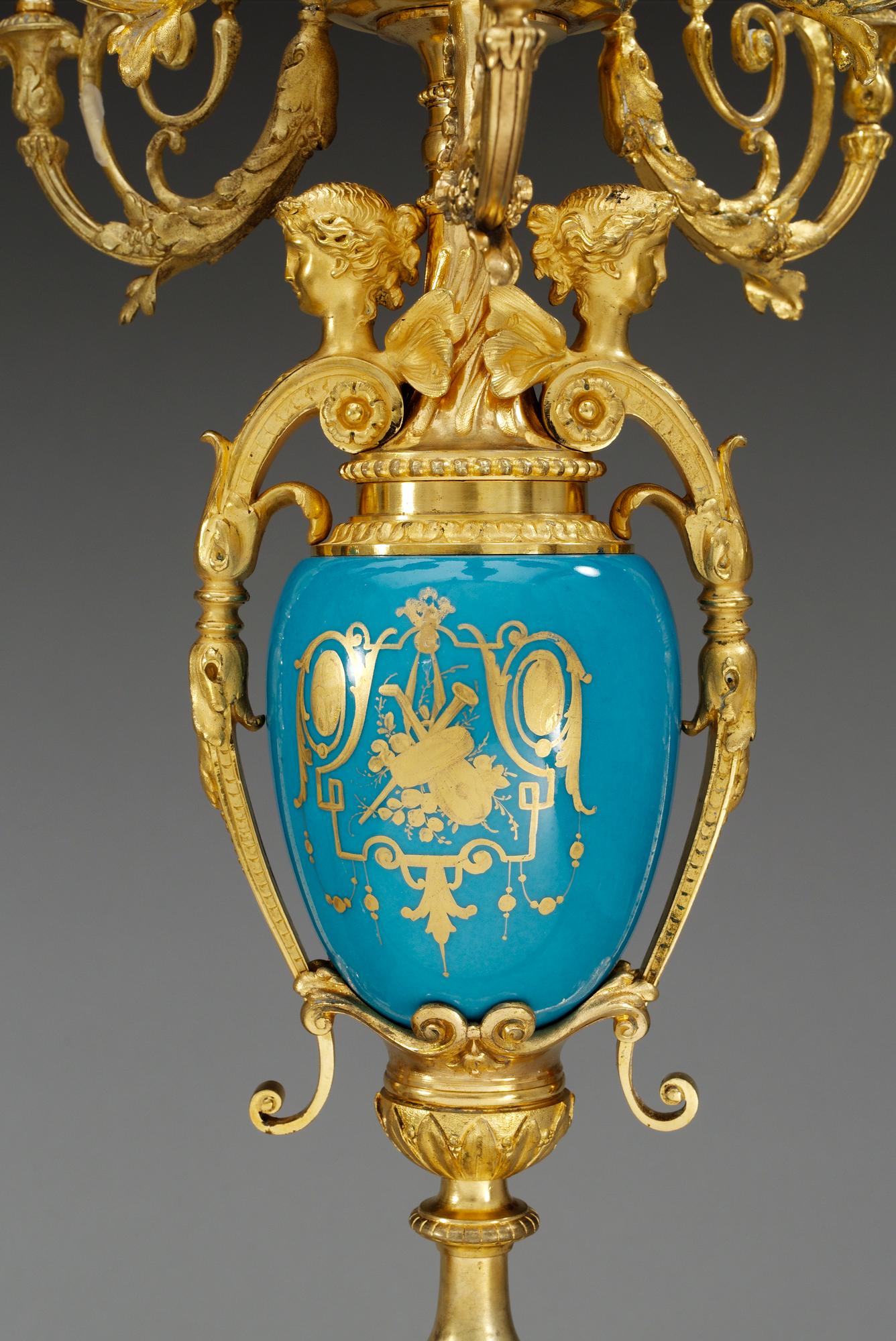 A pair of seven-light gilt bronze chandelabras with porcelain settings, 19th Century, presumably Russian.