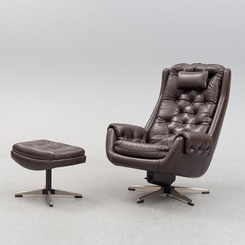 A leather upholstered easy chair with foot stool, 1960's/70's.