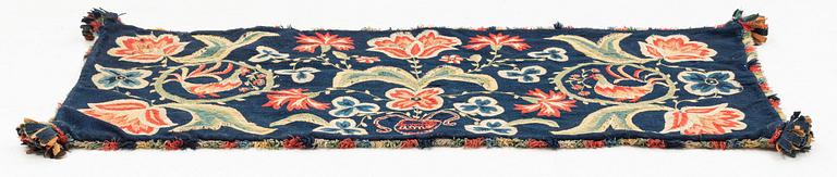 An embroidered carrige cushion, ca 108 x 48 cm, signed AMA, Scania, first half of the 19th century.