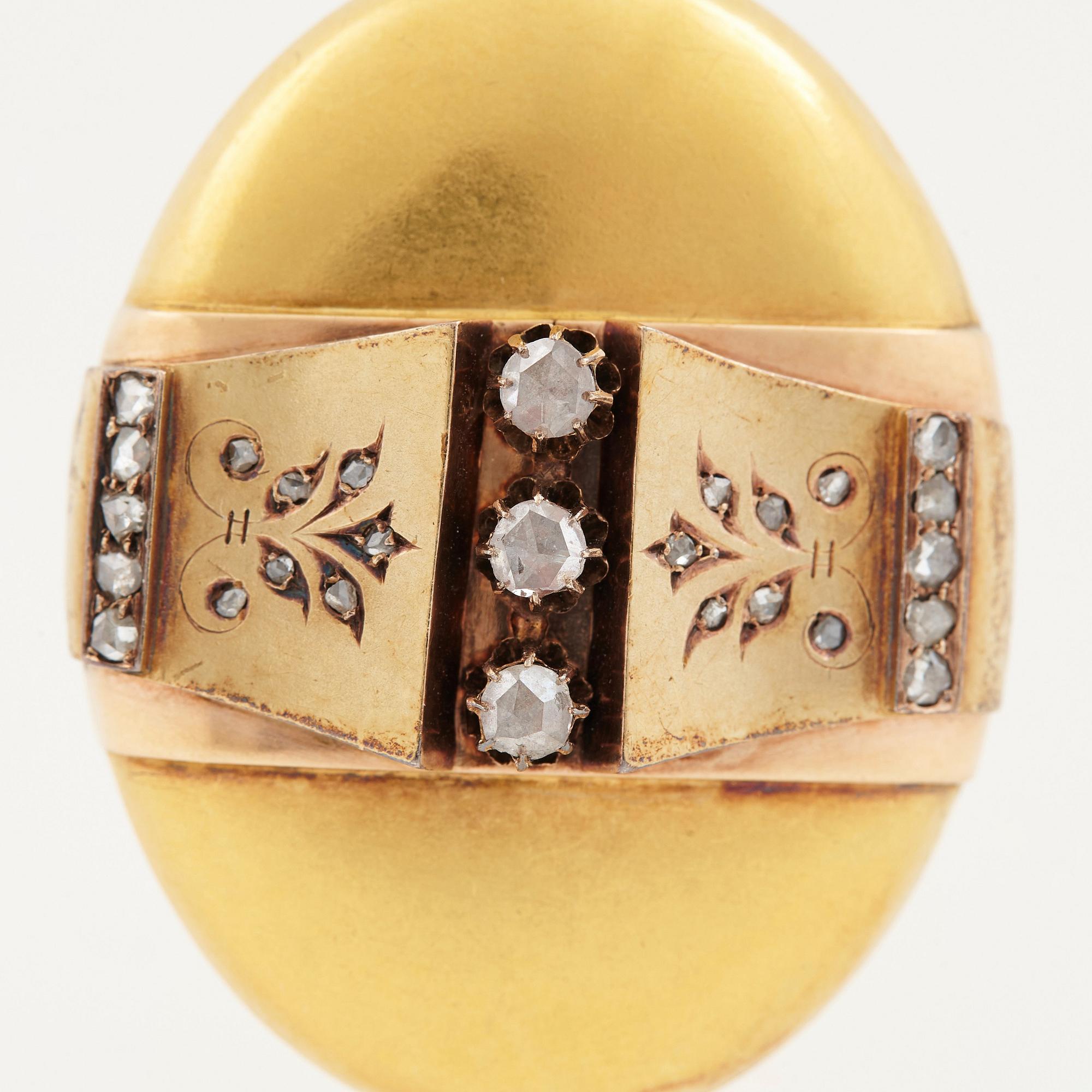 An 18K gold locket set with rose-cut diamonds.
