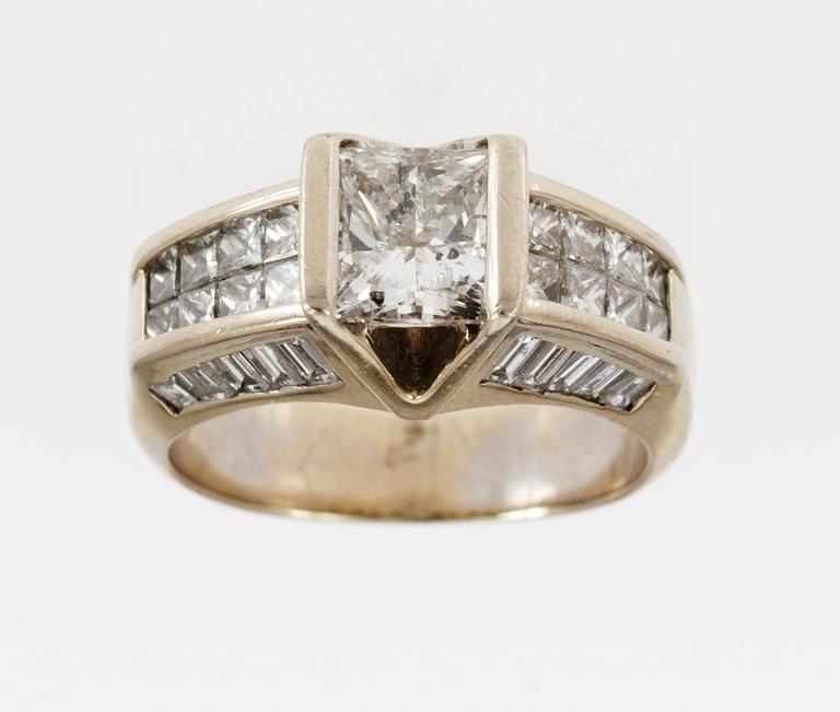 RING, princess cut diamond, app. 1.50 cts, set with smaller princess- and baguette cut diamond, tot. app. 1.30 cts.