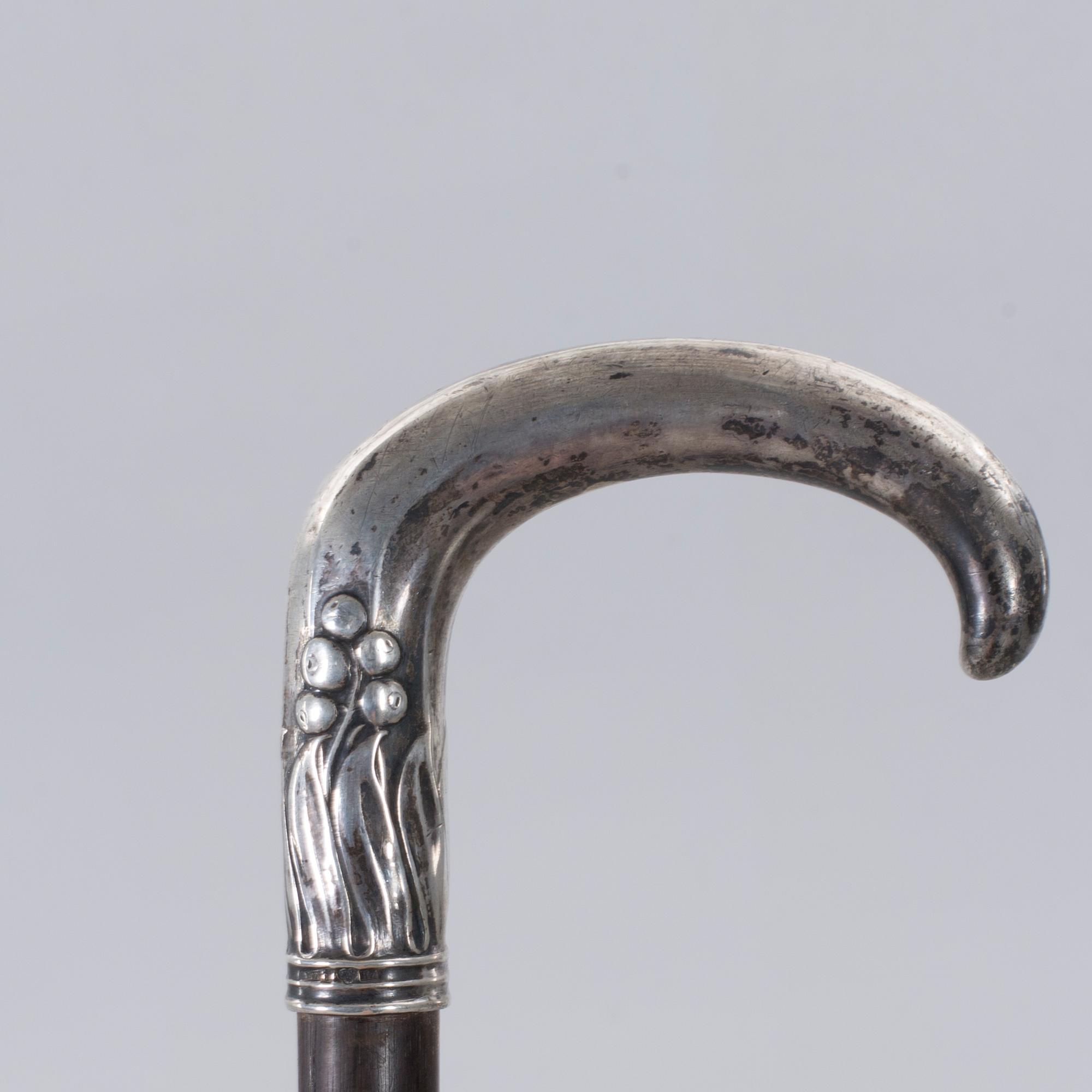 A CANE WITH SILVER MOUNTING, 1910.