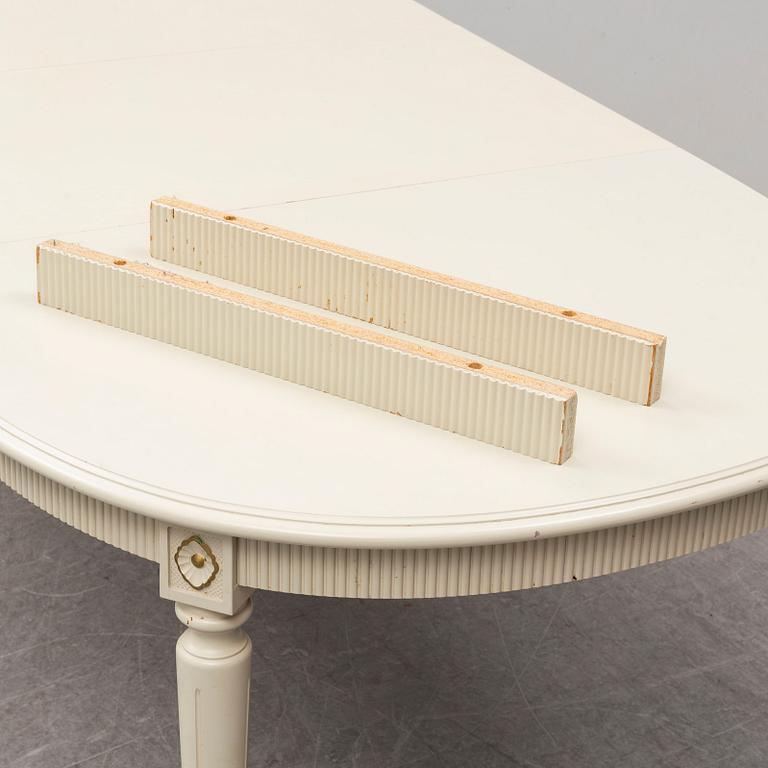A dining table and 4 chairs, second half of the 20th century. 2 leaves included.
