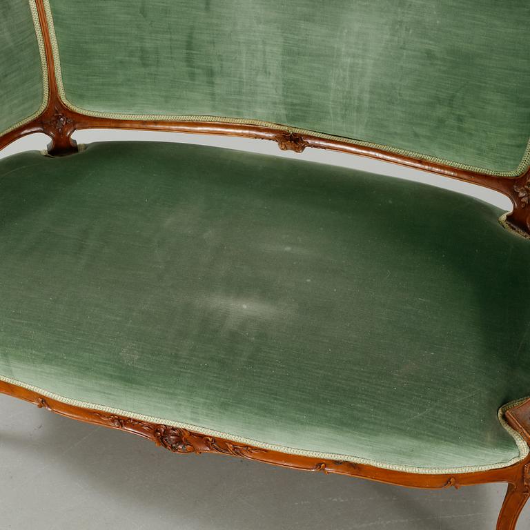A rococo style sofa, two lounge chairs and a table, around the year 1900 and first half of the 20th century.