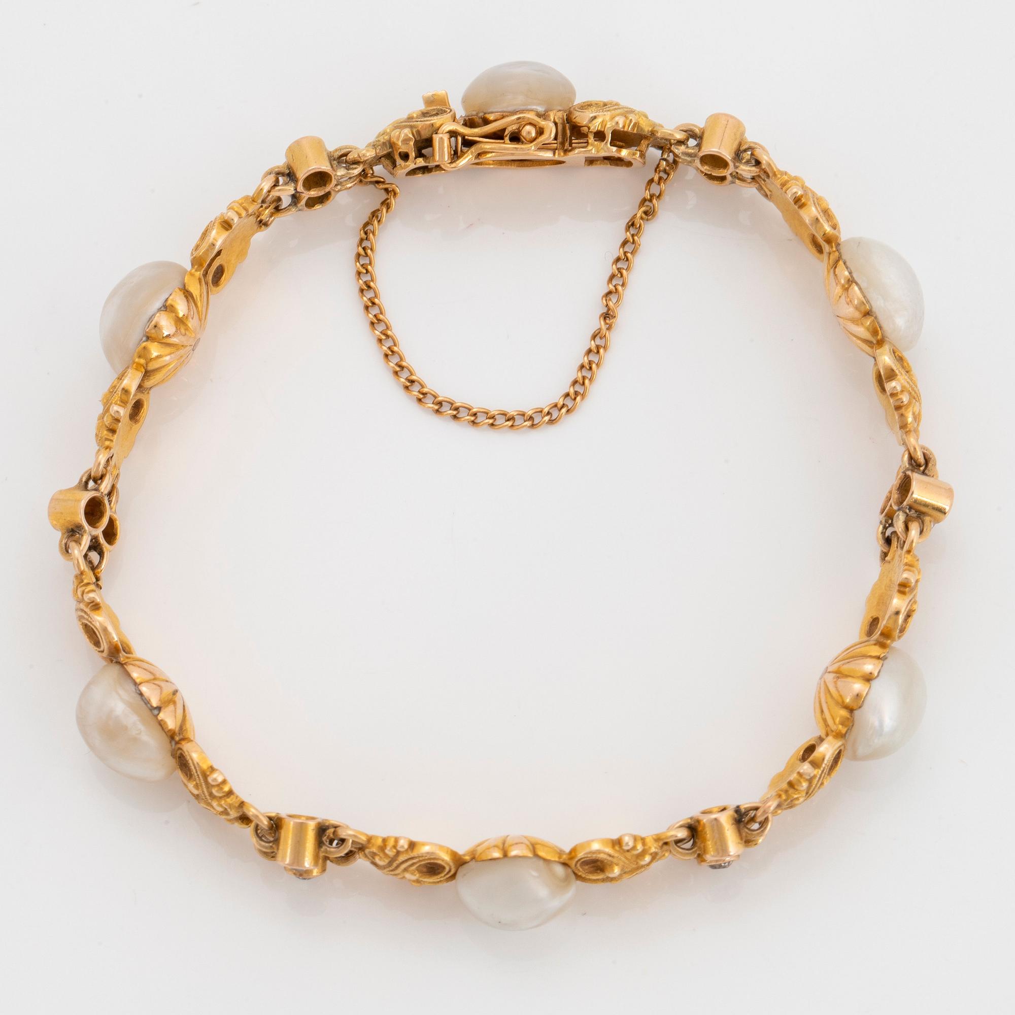 A 14K gold bracelet set with pearls, possibly natural, and old-cut diamonds.