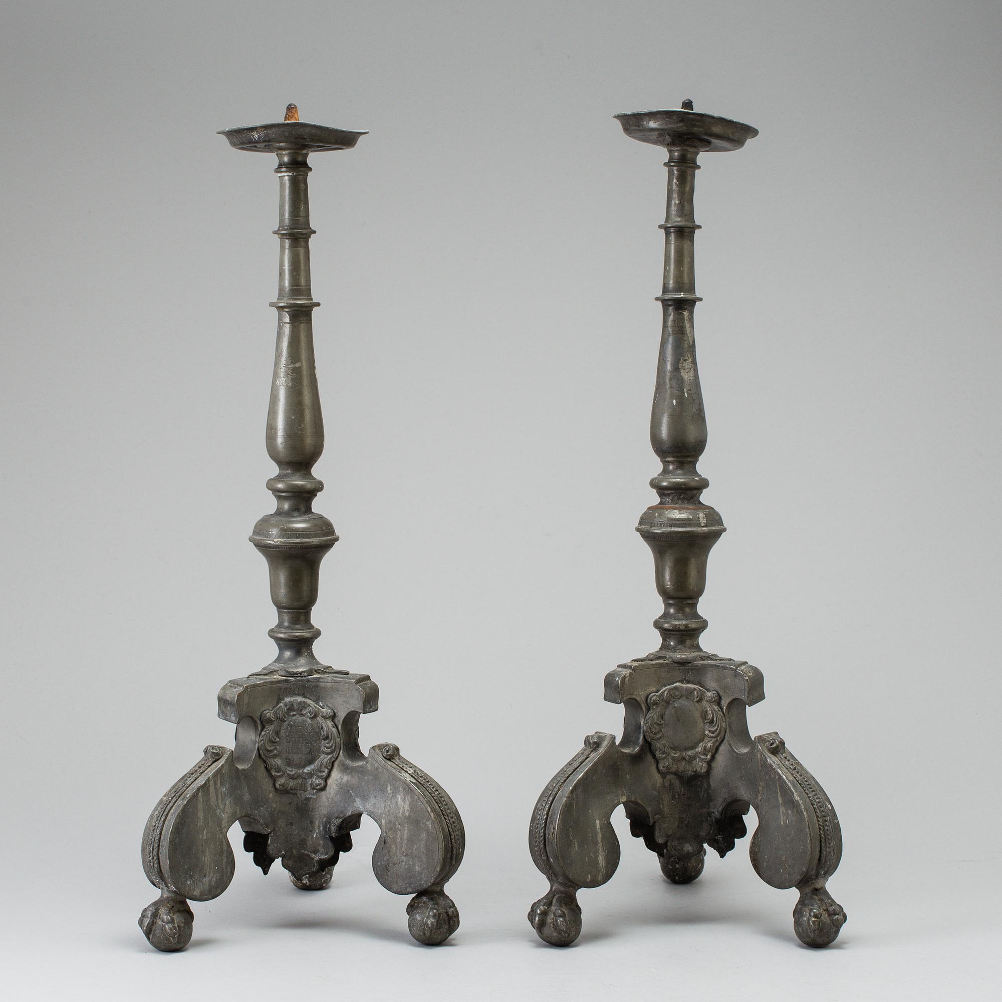 A pair of baroque pewter candlesticks, engraved date 1699.