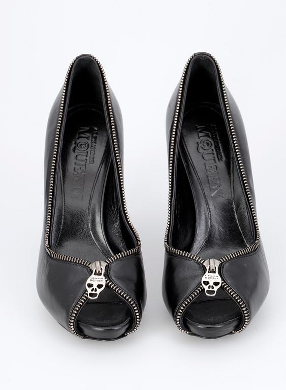 A pair of blck leather shooes by Alexander Mqueen.