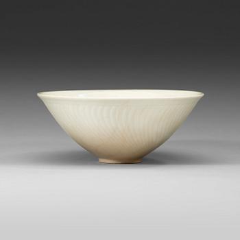 51. A white glazed bowl with incised pattern of flower-scrolls, Qing Dynasty, 18th Century.