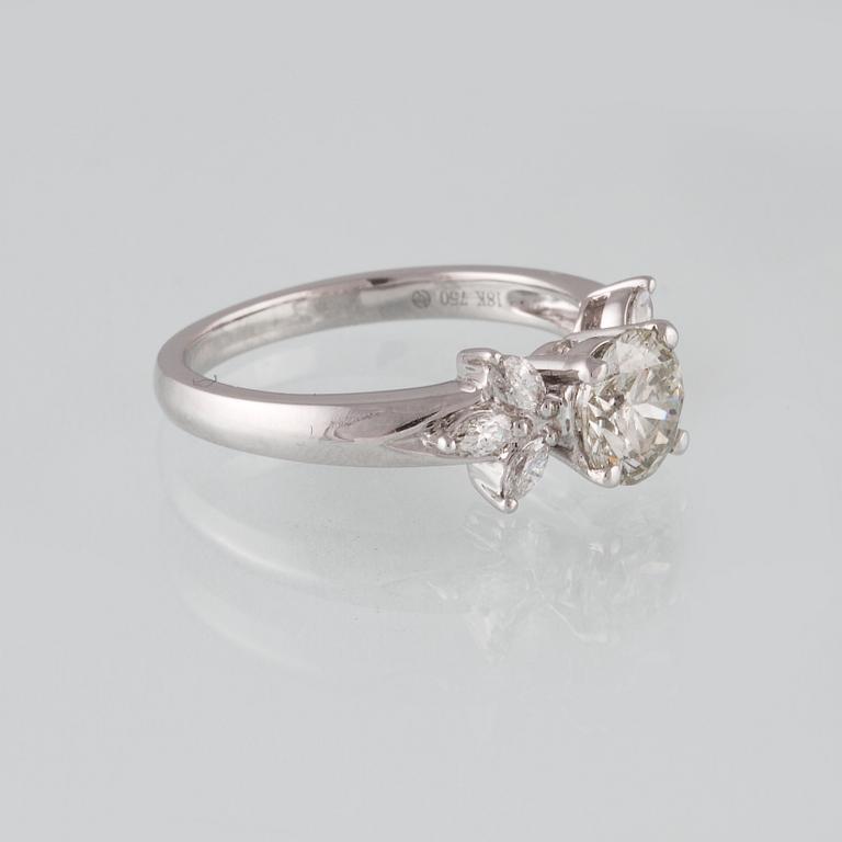 RING, 18K vitguld med briljantslipad diamant ca 1.11 ct samt 6 navetteslipade diamanter 0.26 ct. Vikt 4,2 gram.