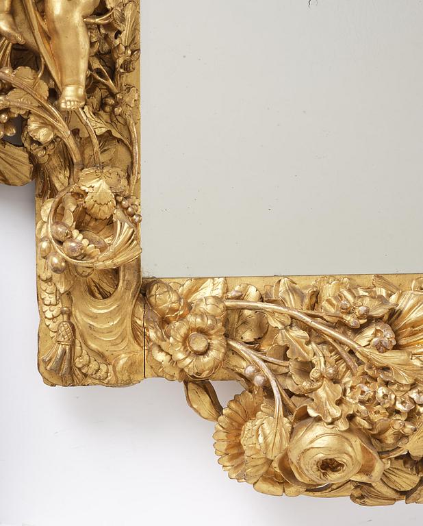 A presumably Dutch Louis XIV carved giltwood frame with mirror glass, in the style of Jean Le Pautre, late 17th century.