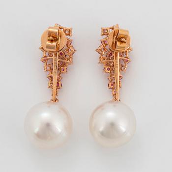 Ett par örhängen med odlade Söderhavspärlor samt runda briljantslipade diamanter och rosa safirer.