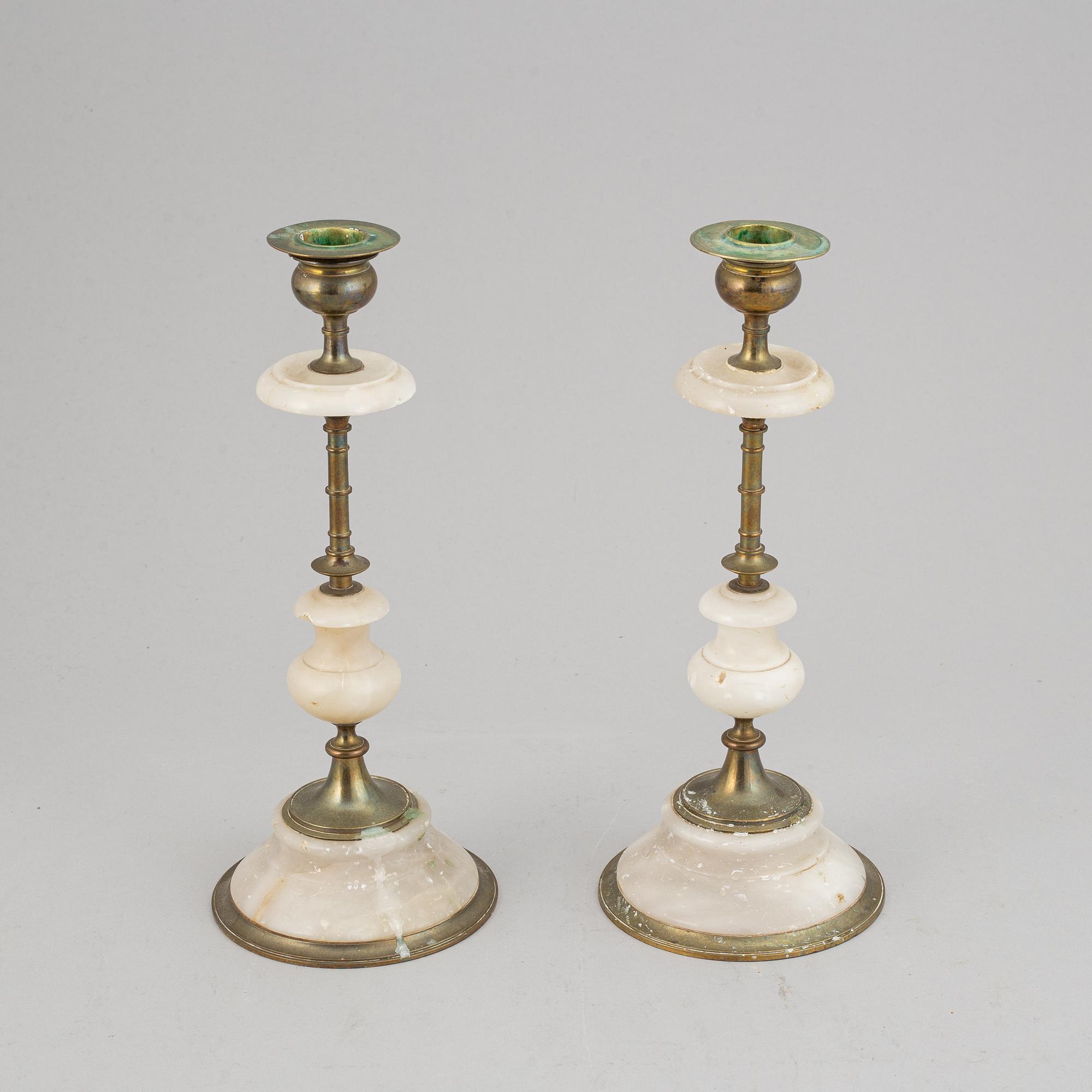 An alabaster mantle clock and pair of candlesticks, circa 1900.