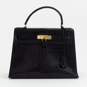 1962 black alligator 'Kelly' handbag by Hermès.